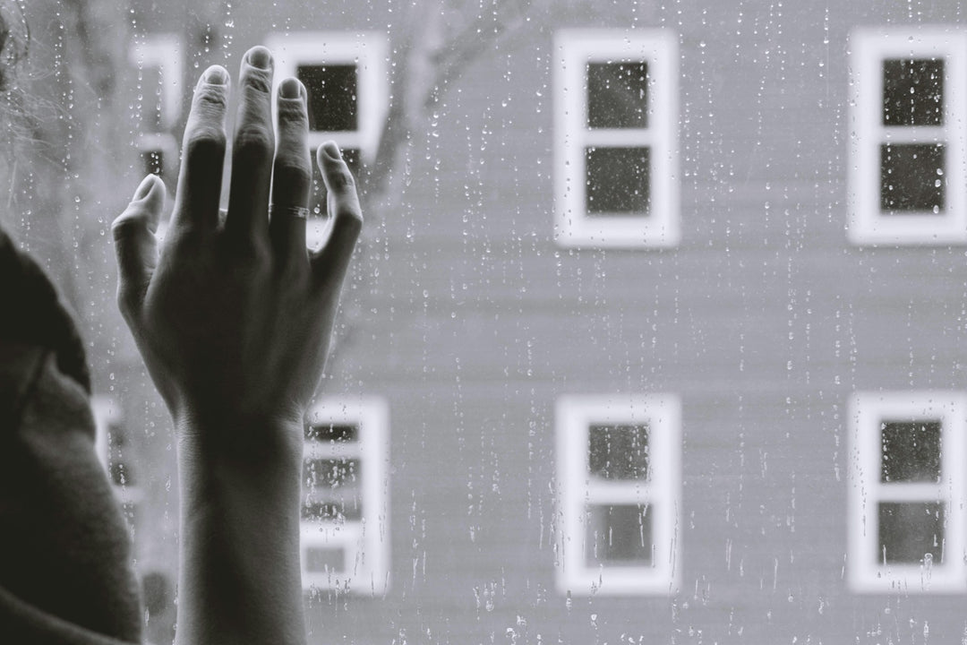 Black and white image of a person holding their hand up