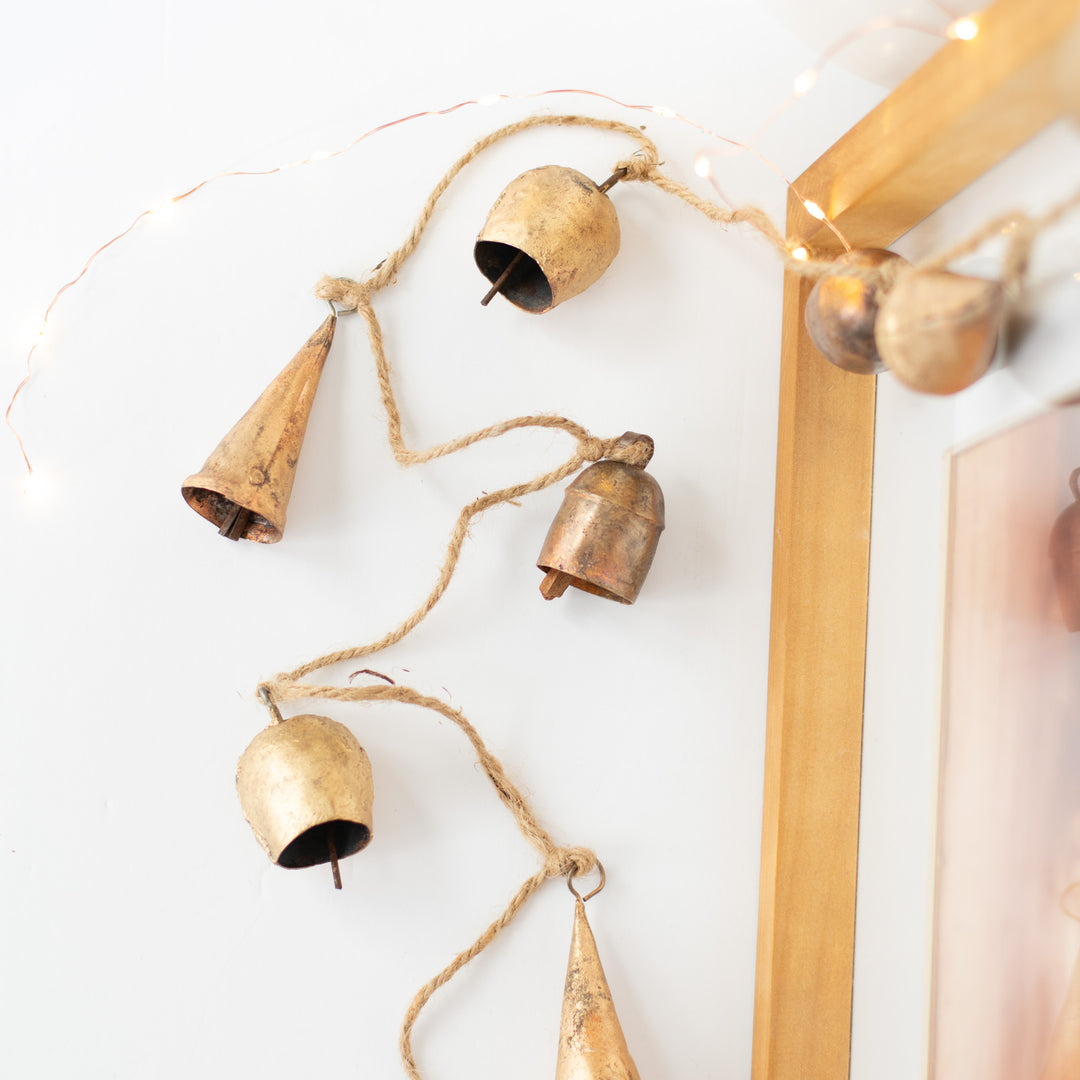 A close-up of a garland with gold bells against a white background