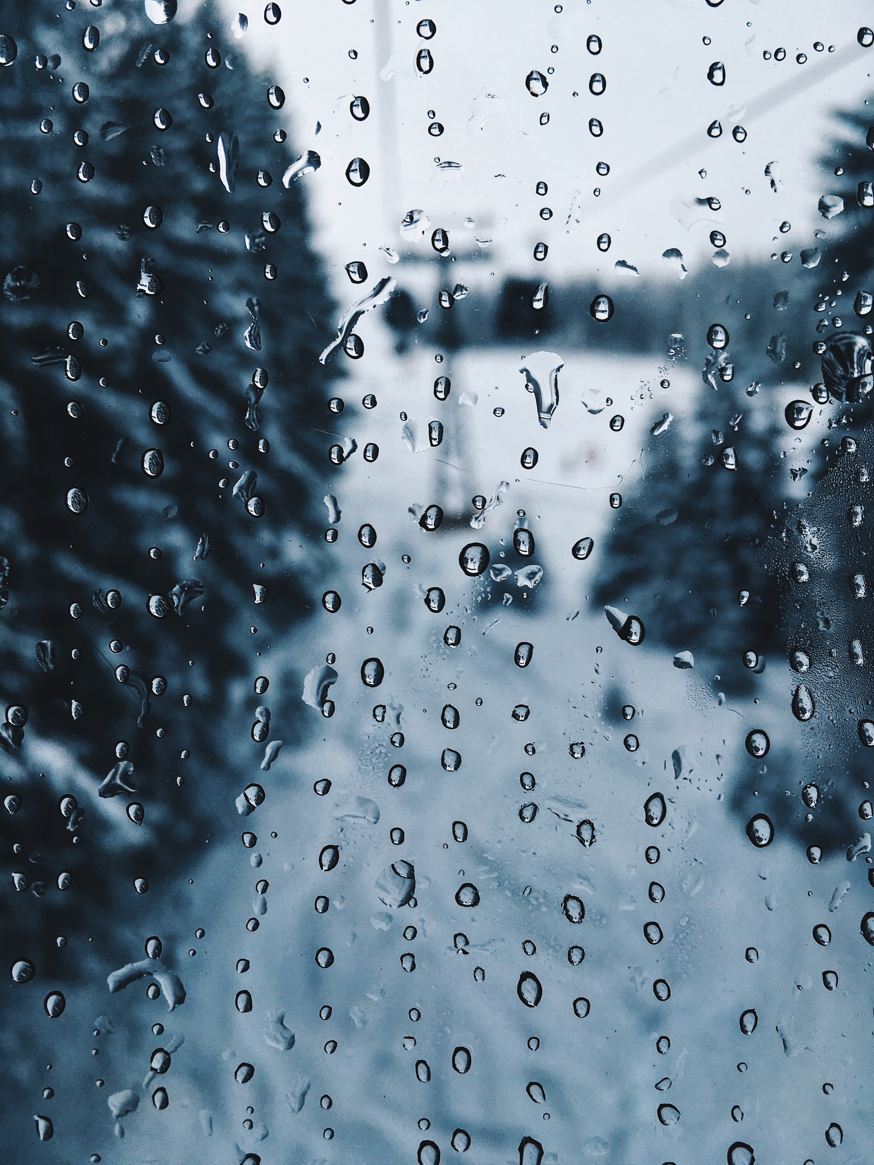 Image of raindrops falling and sticking to a window